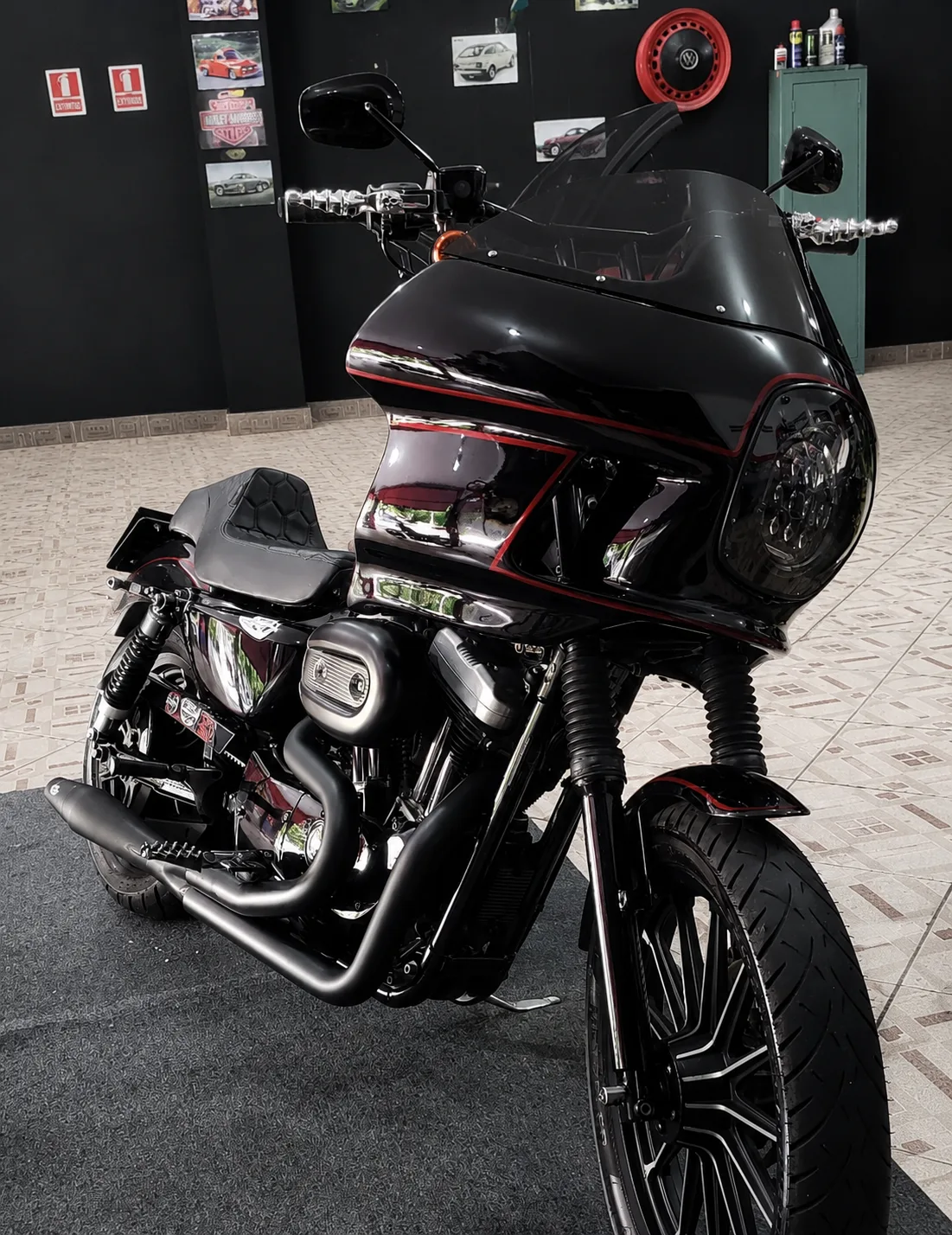 Motocicleta custom preta com fairing FXRT e detalhes vermelhos em ângulo frontal