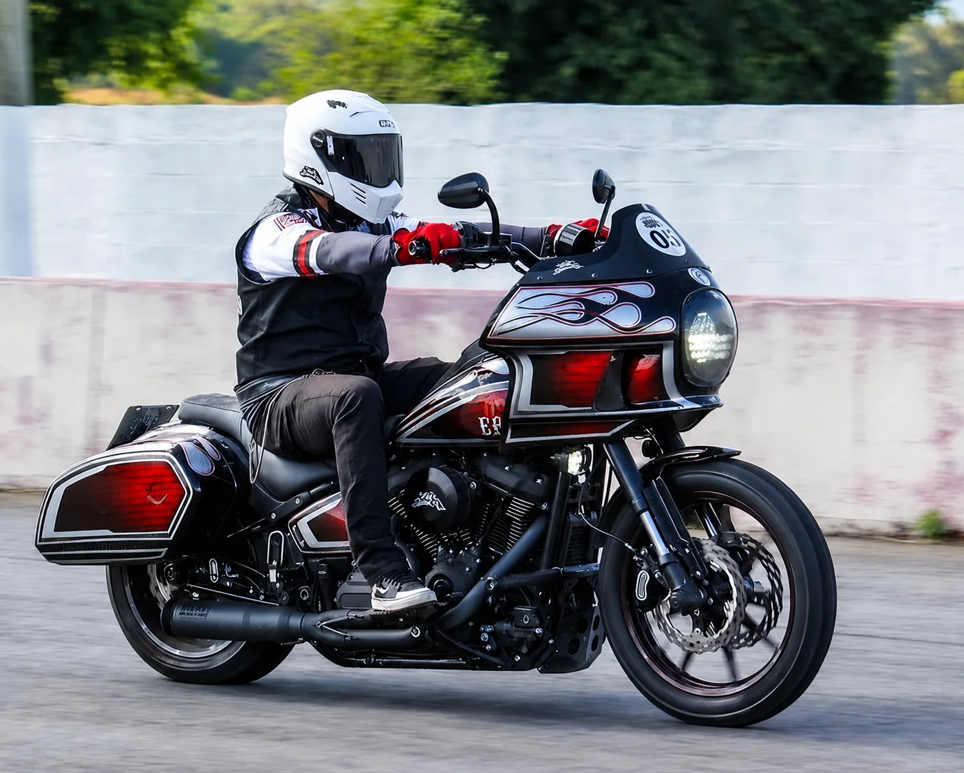 Motociclista conduzindo projeto custom Brotherhood com fairing em movimento