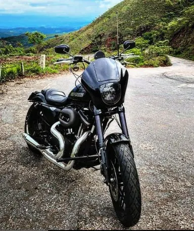 Sportster preta com quarter fairing em estrada de montanha